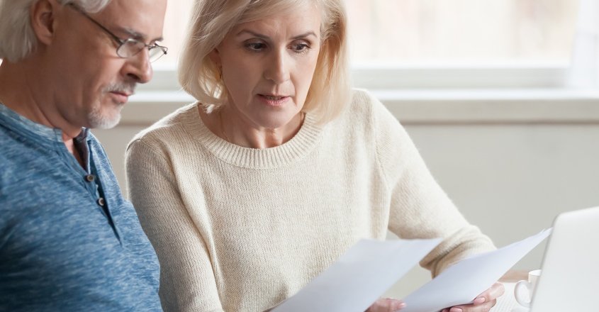 Životní pojištění a sleva na dani: starší pár studuje dokumenty kvůli uplatnění slevy na dani.