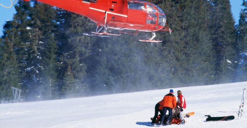 Cestovní pojištění na lyže: vrtulník přistává na sjezdovce u zraněného lyžaře
