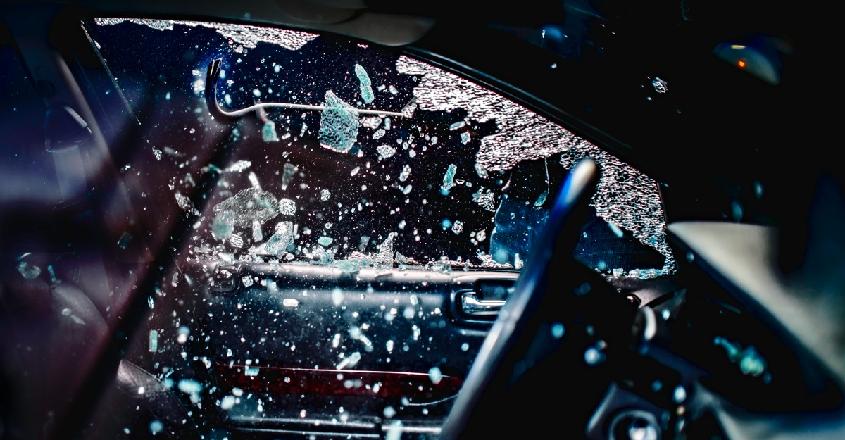 Velké srovnání havarijního pojištění: zloděj rozbíjející okénko u auta.