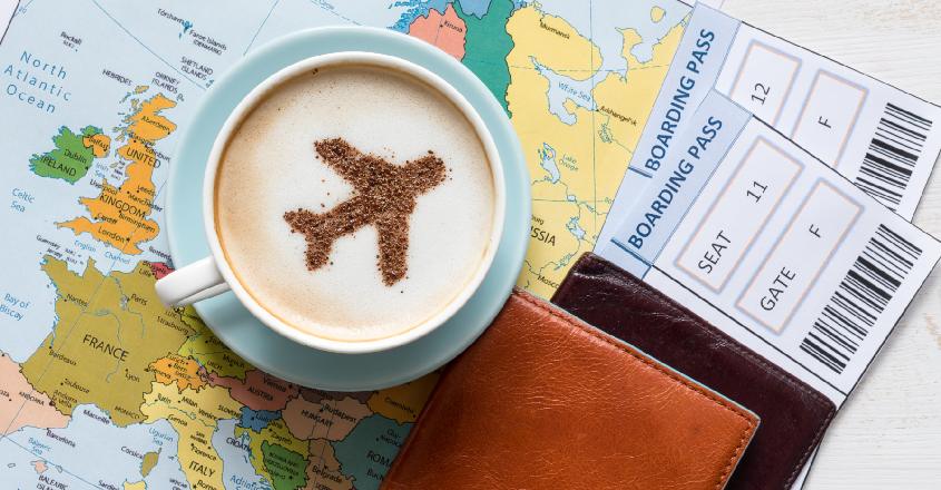 Mapa světa se šálkem kávy, cestovním pasem a letenkami