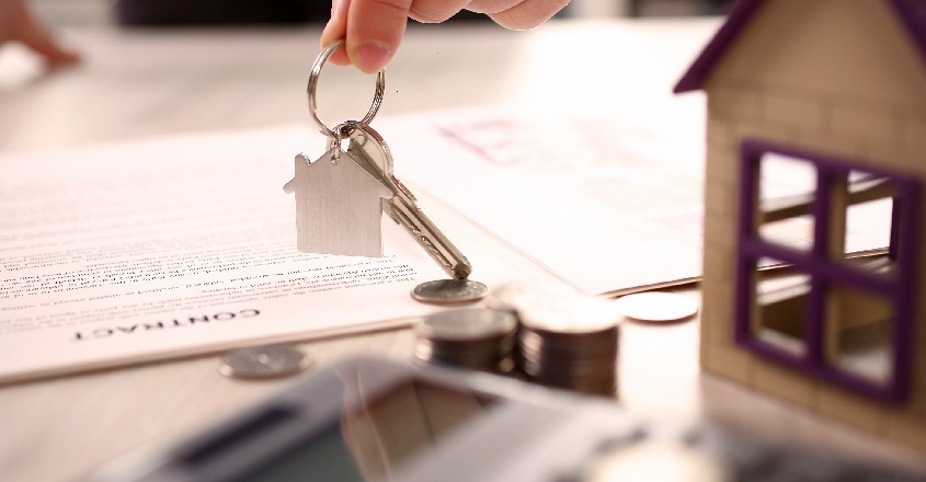 Hypoteční smlouva s klíči od nemovitosti a mincemi