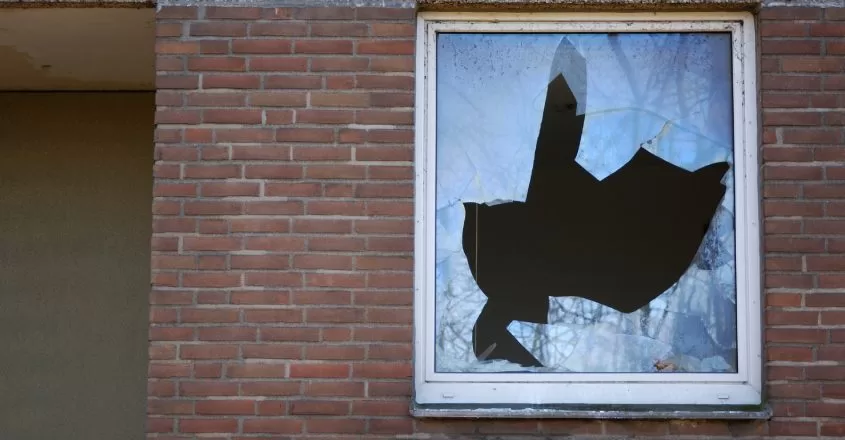 Rozbité okno v cihlové budově