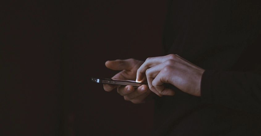Zjistěte, jak bezpečně komunikovat a rozpoznat nebezpečné triky, které mohou ohrozit vaši rodinu. Muž píše zprávu na svém mobilním telefonu