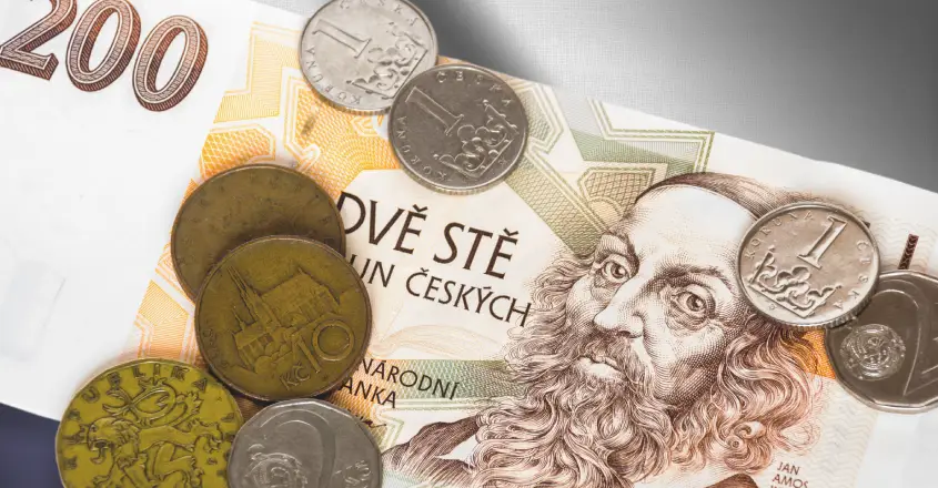 české mince a bankovky položené na české vlajce