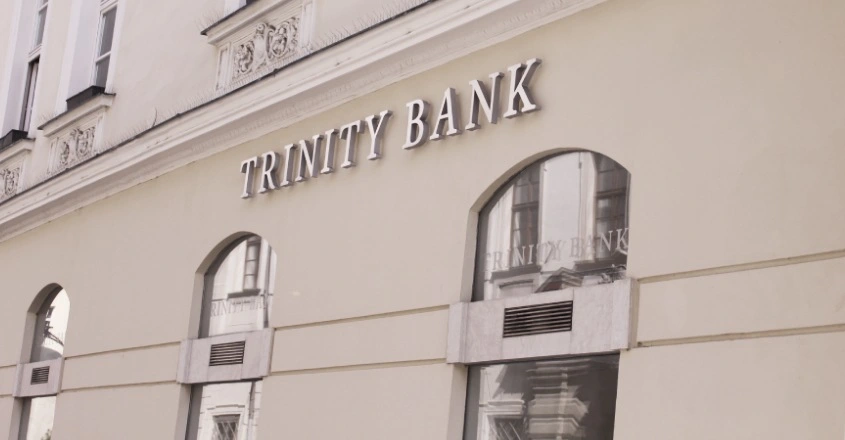 Refinancování úvěrů u Trinity Bank přináší klientům možnost zjednodušit splácení a získat lepší přehled o osobních financích. Nápis Trinity bank na budově